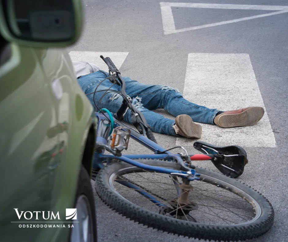 wypadek rowerowy bez kasku, człowiek leży na ulicy. logo votum odszkodowania