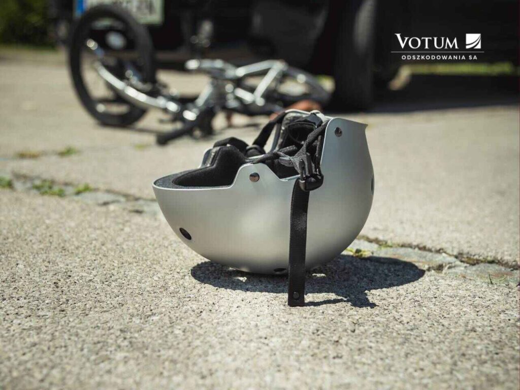 Wypadek komunikacyjny z udziałem rowerzysty - kask leży na ulicy. Sprawca wypadku komunikacyjnego jest winny.