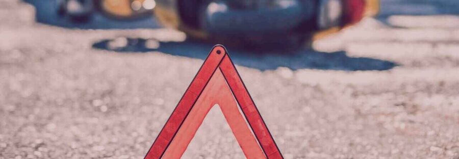 Trójkąt ostrzegawczy ustawiony w miejscu wypadku komunikacyjnego. Po takim zdarzeniu można dociekać odszkodowania z OC sprawcy.