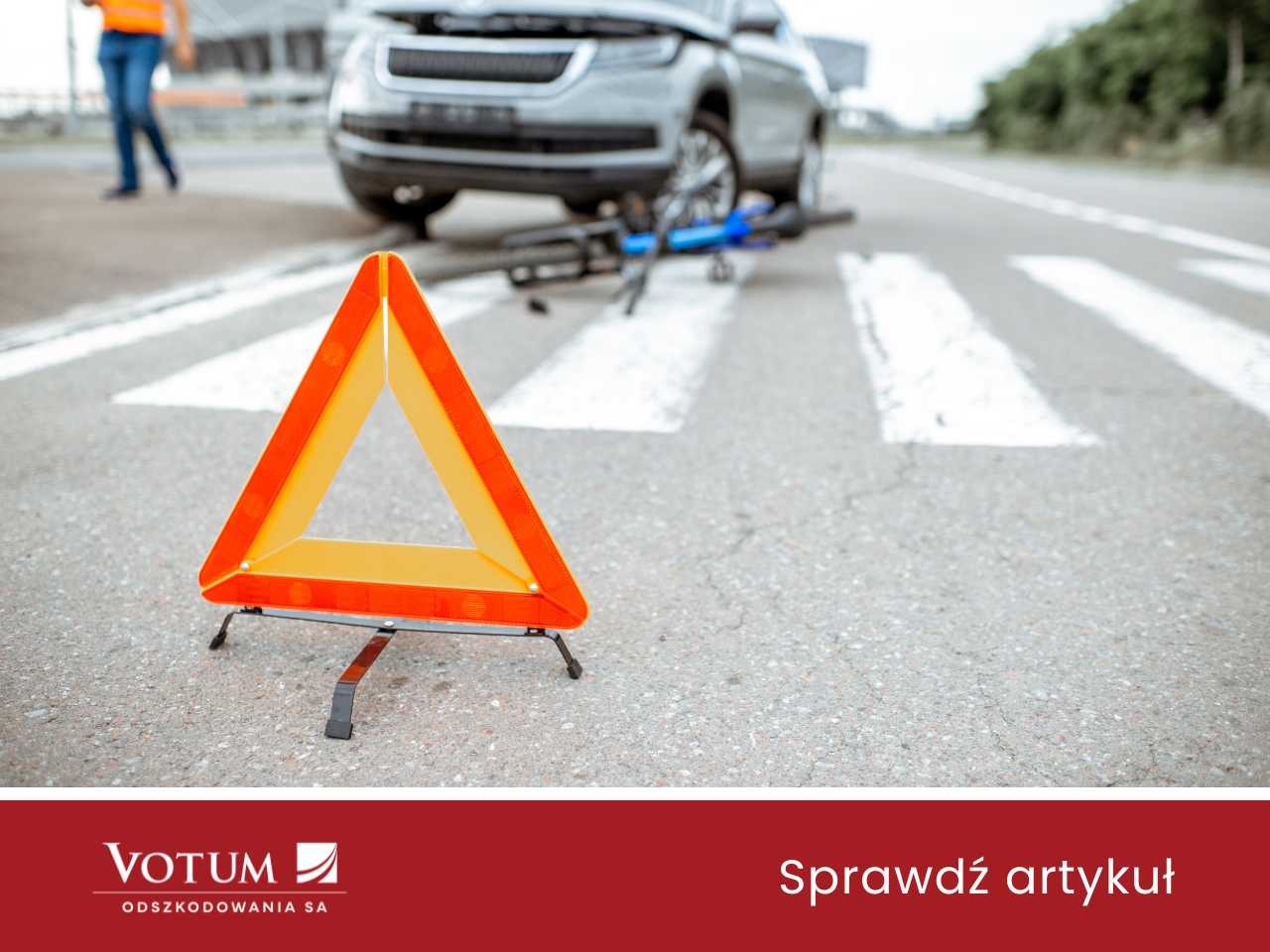 Trójkąt ustawiony przed pasami, na których jest auto i rower