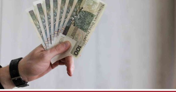 Męska dłoń trzyma wachlarz banknotów stuzłotowych na tle grafiki informacyjnej o rencie z OC sprawcy.