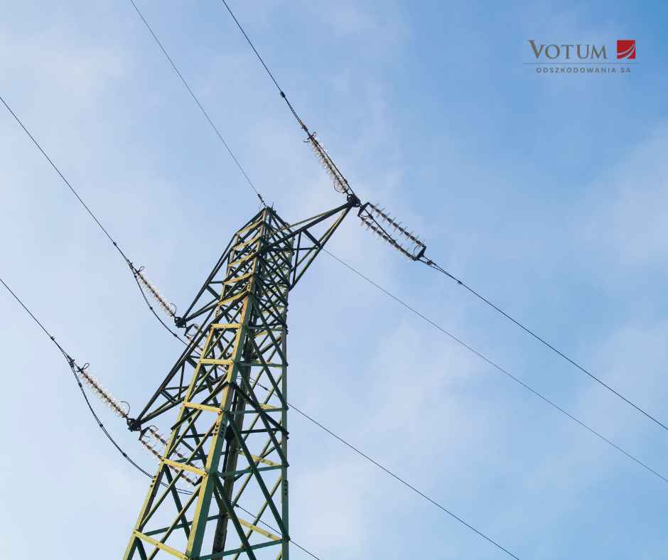 Stalowy słup elektroenergetyczny wysokiego napięcia na tle błękitnego nieba – odszkodowanie za słupy energetyczne na polu.